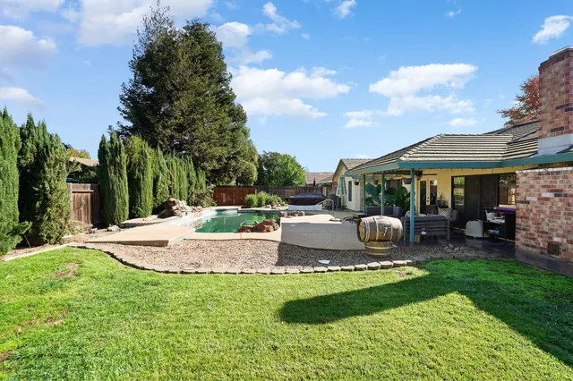 a view of a house with backyard and sitting area