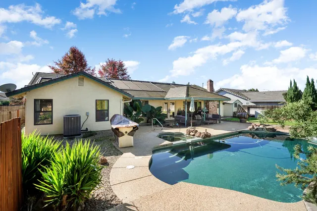 a view of a house with swimming pool and sitting area