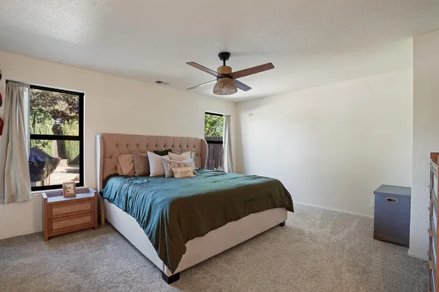 a bedroom with a bed and a ceiling fan