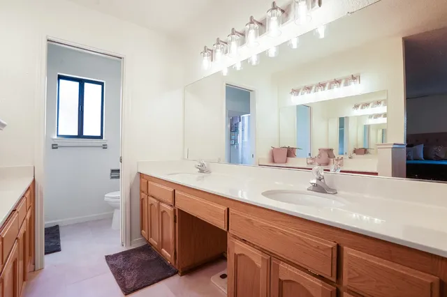 a bathroom with a double vanity sink and a mirror