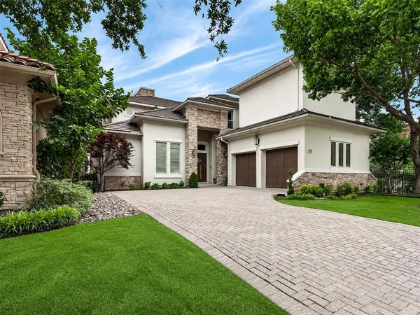 a front view of a house with a garden and yard