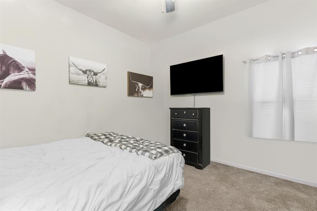 419 George Drive Fate, TX 75189 - Photo 21 of 26 a bedroom with a bed and a flat screen tv
