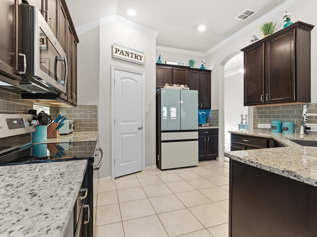 419 George Drive Fate, TX 75189 - Photo 9 of 26 a kitchen with stainless steel appliances granite countertop a refrigerator a stove and a sink