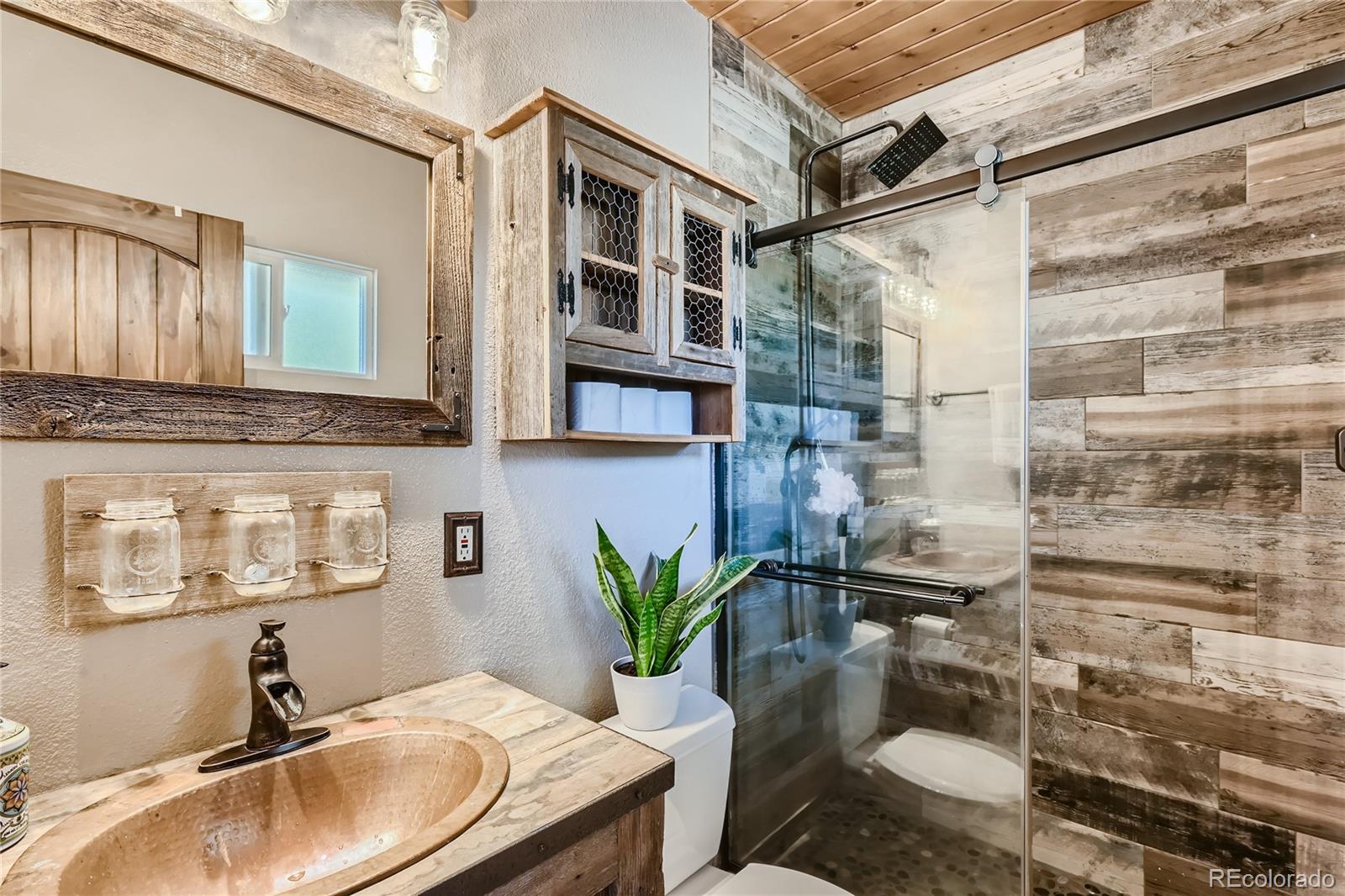 938 Valley Road Evergreen, CO 80439 - Photo 12 of 24 a bathroom with a granite countertop sink a mirror and shower