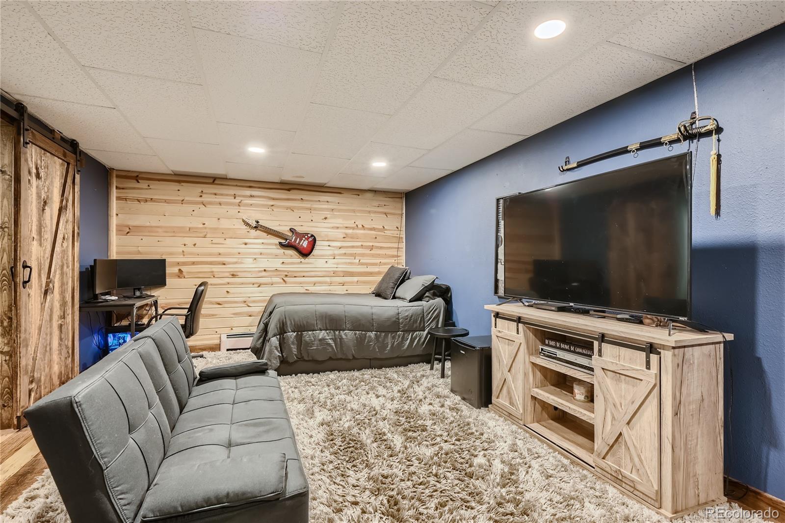 938 Valley Road Evergreen, CO 80439 - Photo 19 of 24 a bedroom with furniture and a flat screen tv