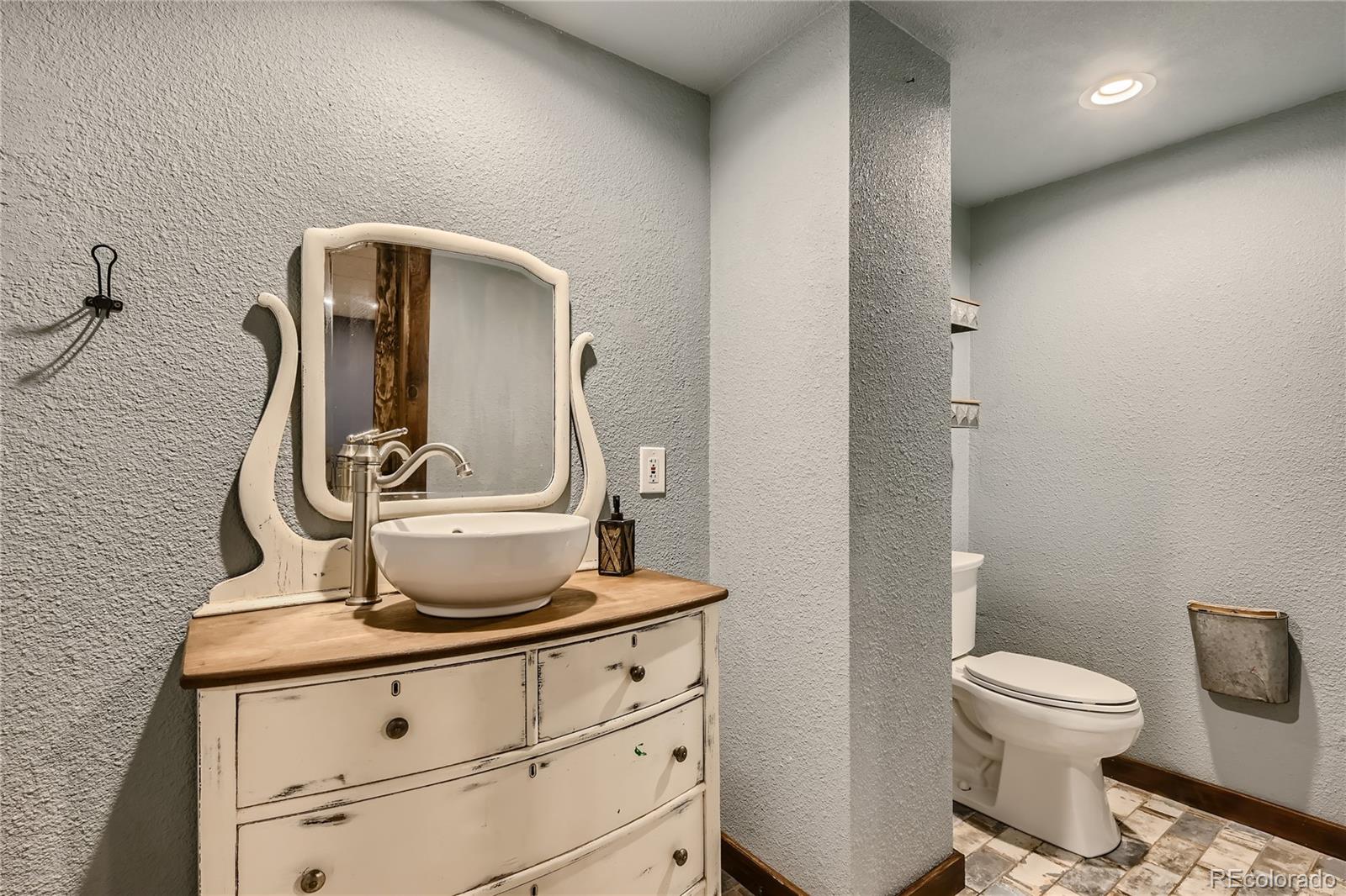 938 Valley Road Evergreen, CO 80439 - Photo 20 of 24 a bathroom with a toilet sink and mirror