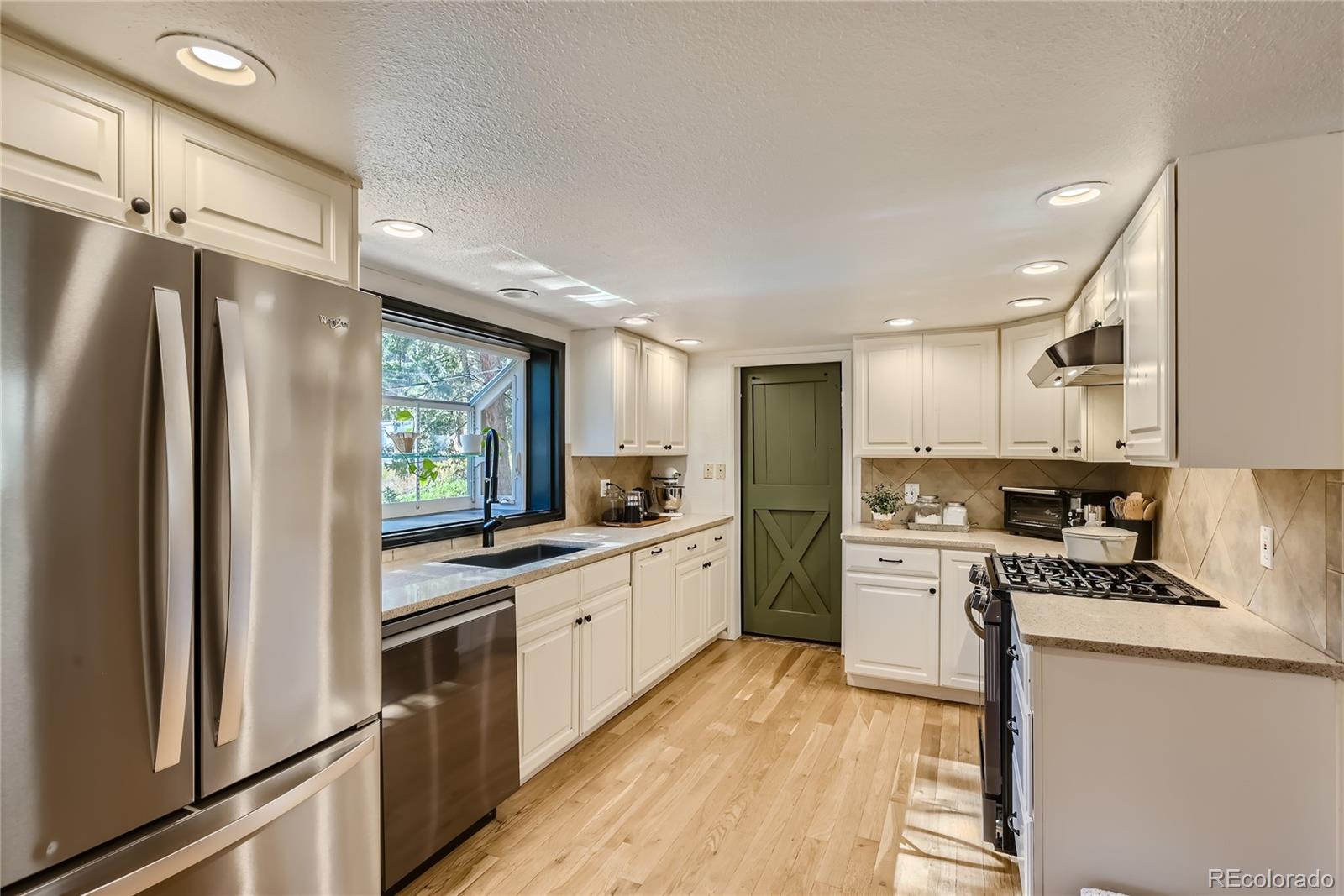 938 Valley Road Evergreen, CO 80439 - Photo 9 of 24 a kitchen with white cabinets and stainless steel appliances