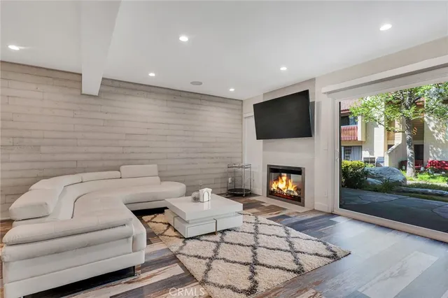 a living room with furniture a fireplace and a flat screen tv