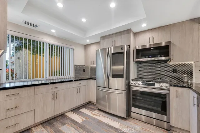 a kitchen with granite countertop a stove a sink and a refrigerator