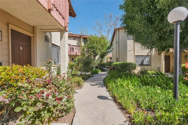 a couple of flower plants in front of yellow house