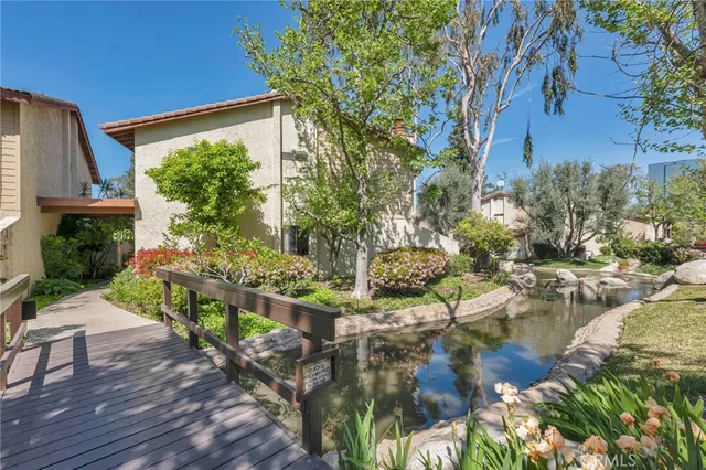 a view of swimming pool with lawn chairs and plants