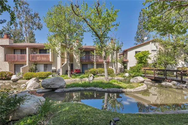 a view of a house with backyard water fountain and sitting area