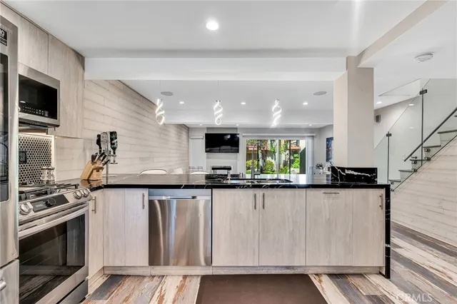 a kitchen with granite countertop a sink and stainless steel appliances