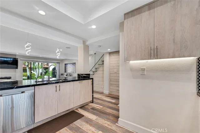 a kitchen with granite countertop a sink and a white wooden cabinets