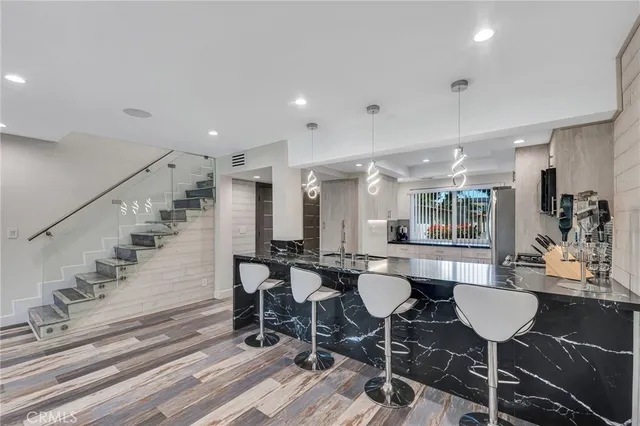 a dining hall with stainless steel appliances a dining table and chairs with wooden floor