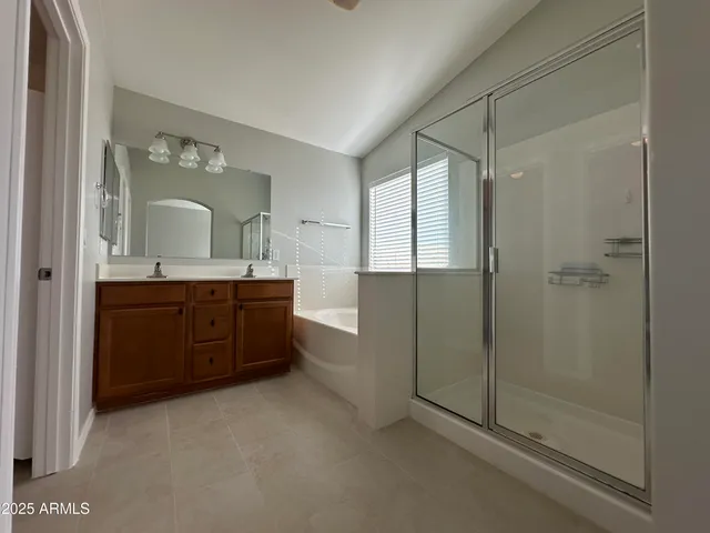 a spacious bathroom with a shower sink and mirror