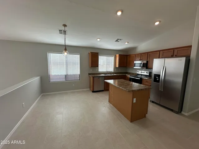 a kitchen with stainless steel appliances granite countertop a refrigerator a sink a stove a microwave a counter space and cabinets