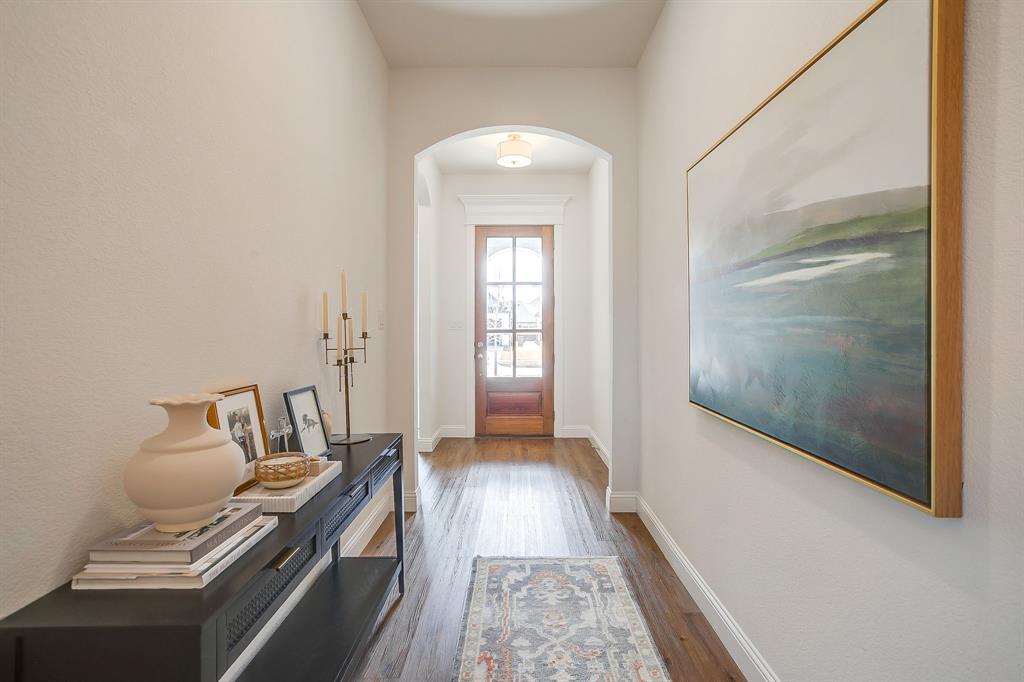 208 Observation Drive West Aledo, TX 76008 - Photo 2 of 23 a view of a hallway with wooden floor and a living room