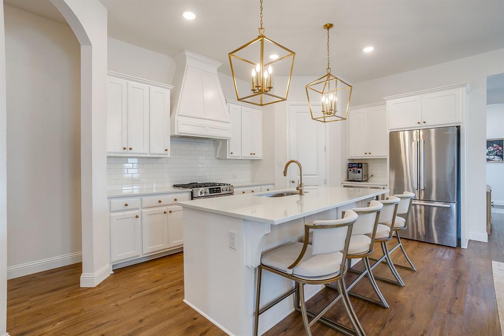 208 Observation Drive West Aledo, TX 76008 - Photo 4 of 23 a kitchen with stainless steel appliances a stove a sink island and a refrigerator