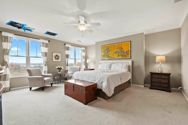 a spacious bedroom with a bed couch and window