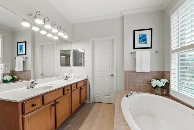 a spacious bathroom with a tub sink and mirror