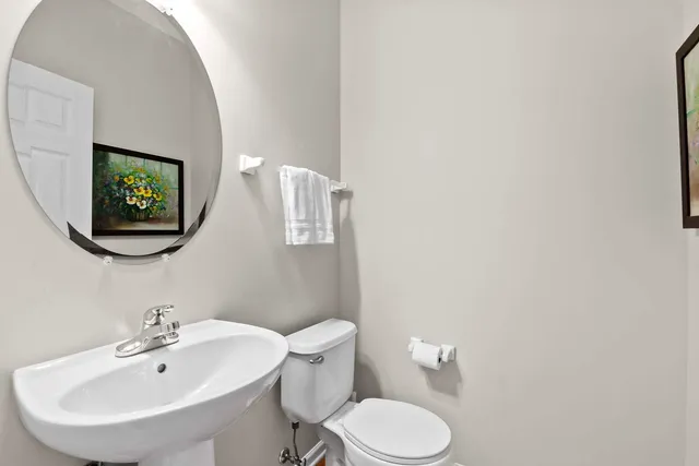 a bathroom with a toilet a sink and mirror