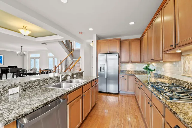a kitchen with stainless steel appliances granite countertop a sink stove and refrigerator