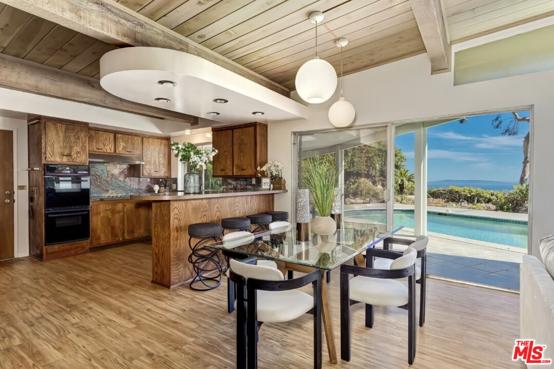 1126 Tellem Drive Pacific Palisades, CA 90272 - Photo 16 of 46 a view of a dining room with furniture window and wooden floor