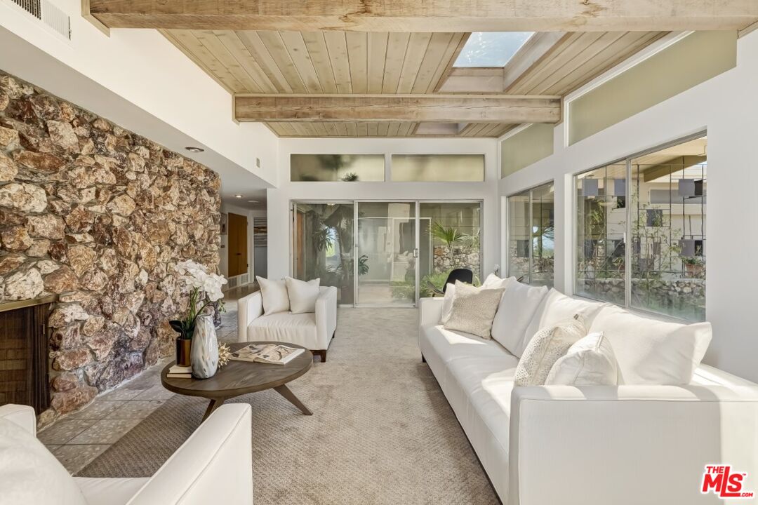 1126 Tellem Drive Pacific Palisades, CA 90272 - Photo 24 of 46 a living room with furniture and a floor to ceiling window