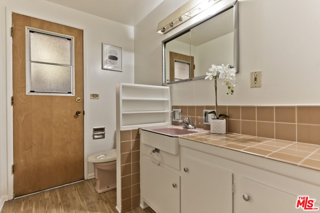 1126 Tellem Drive Pacific Palisades, CA 90272 - Photo 28 of 46 a bathroom with a granite countertop sink and a mirror