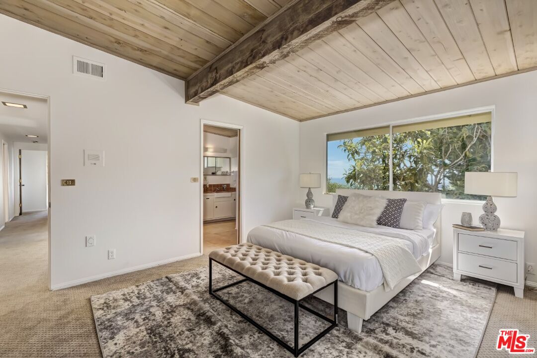 1126 Tellem Drive Pacific Palisades, CA 90272 - Photo 37 of 46 a bedroom with a bed a dresser and a large window