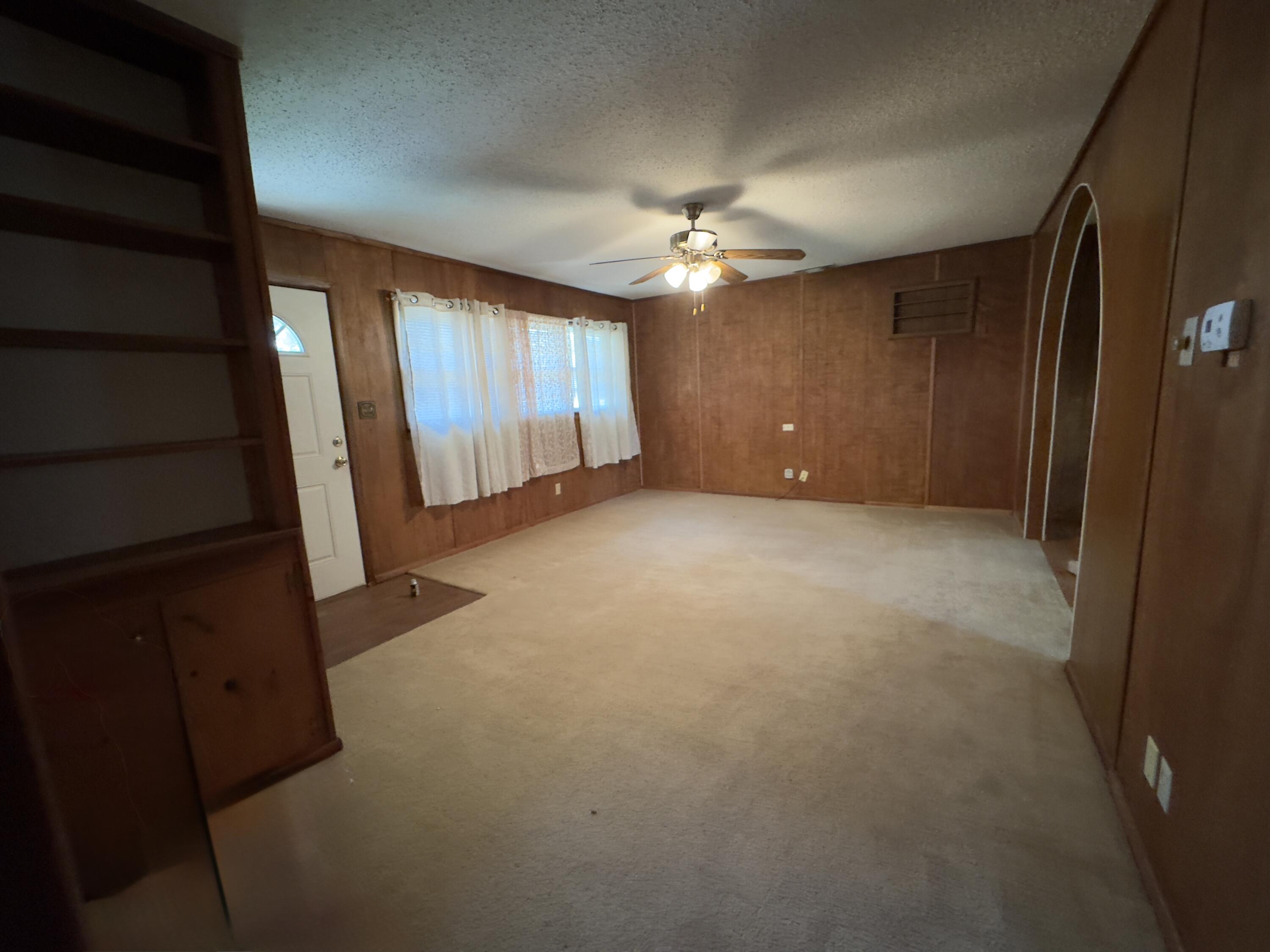 955 South 20th Street Slaton, TX 79364 - Photo 5 of 14 wooden floor in an empty room with a window