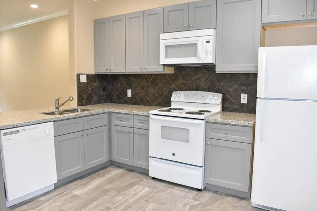 a kitchen with white cabinets and white appliances