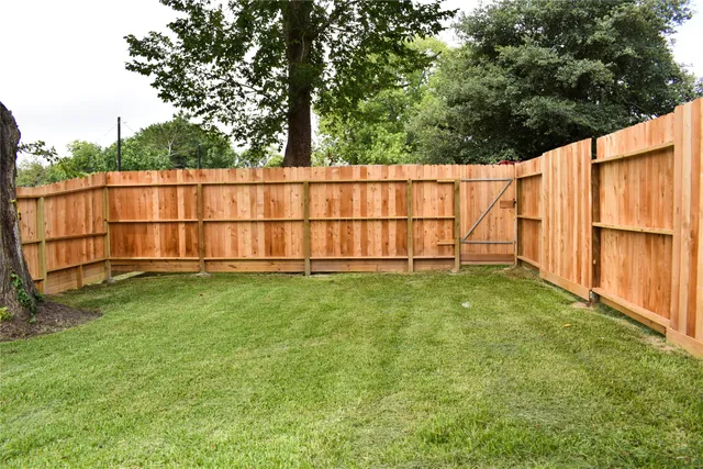 a view of a backyard with wooden fence