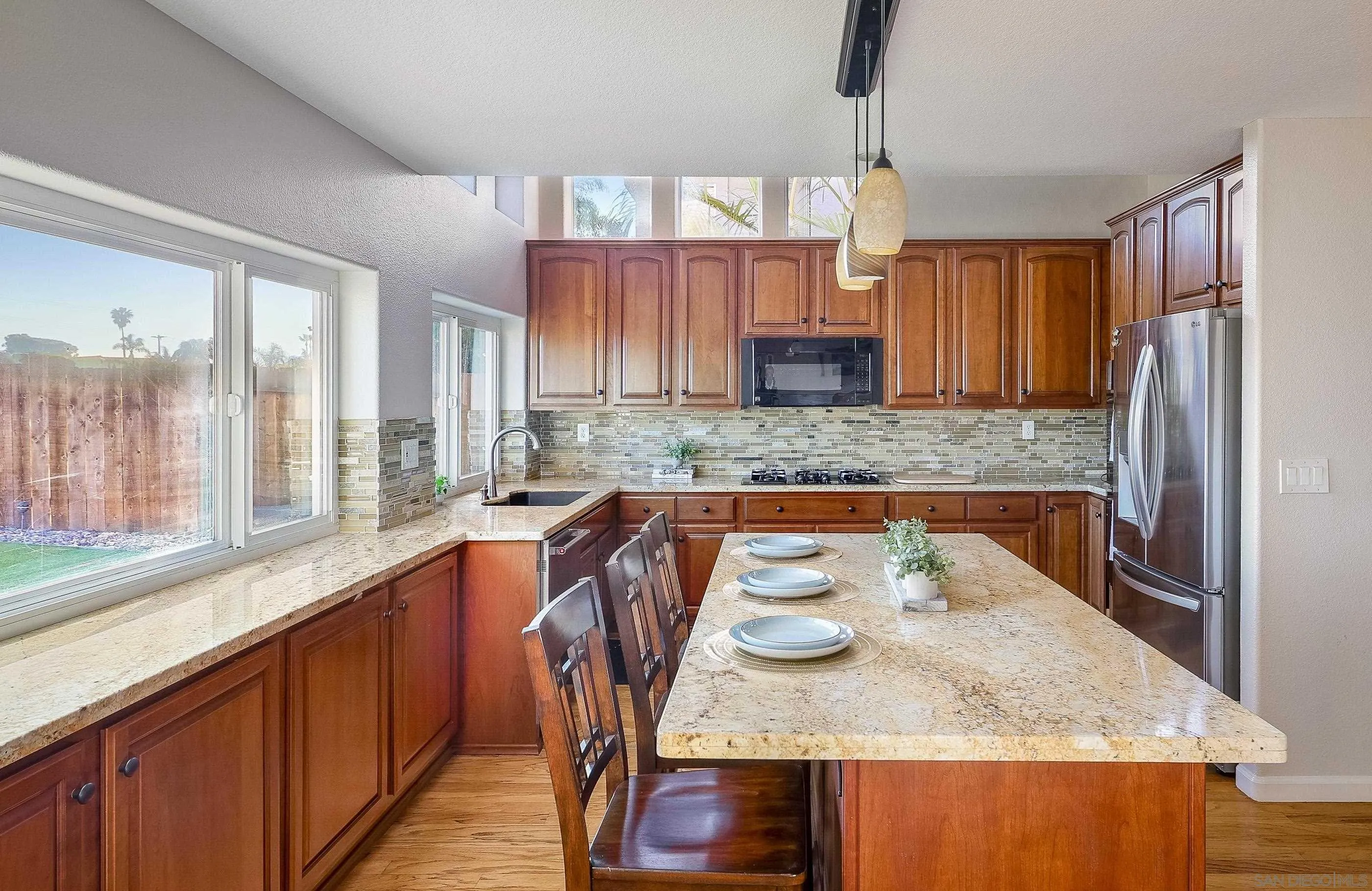 2347 Terraza Ribera Carlsbad, CA 92009 - Photo 12 of 42 a kitchen with kitchen island granite countertop a sink and a refrigerator