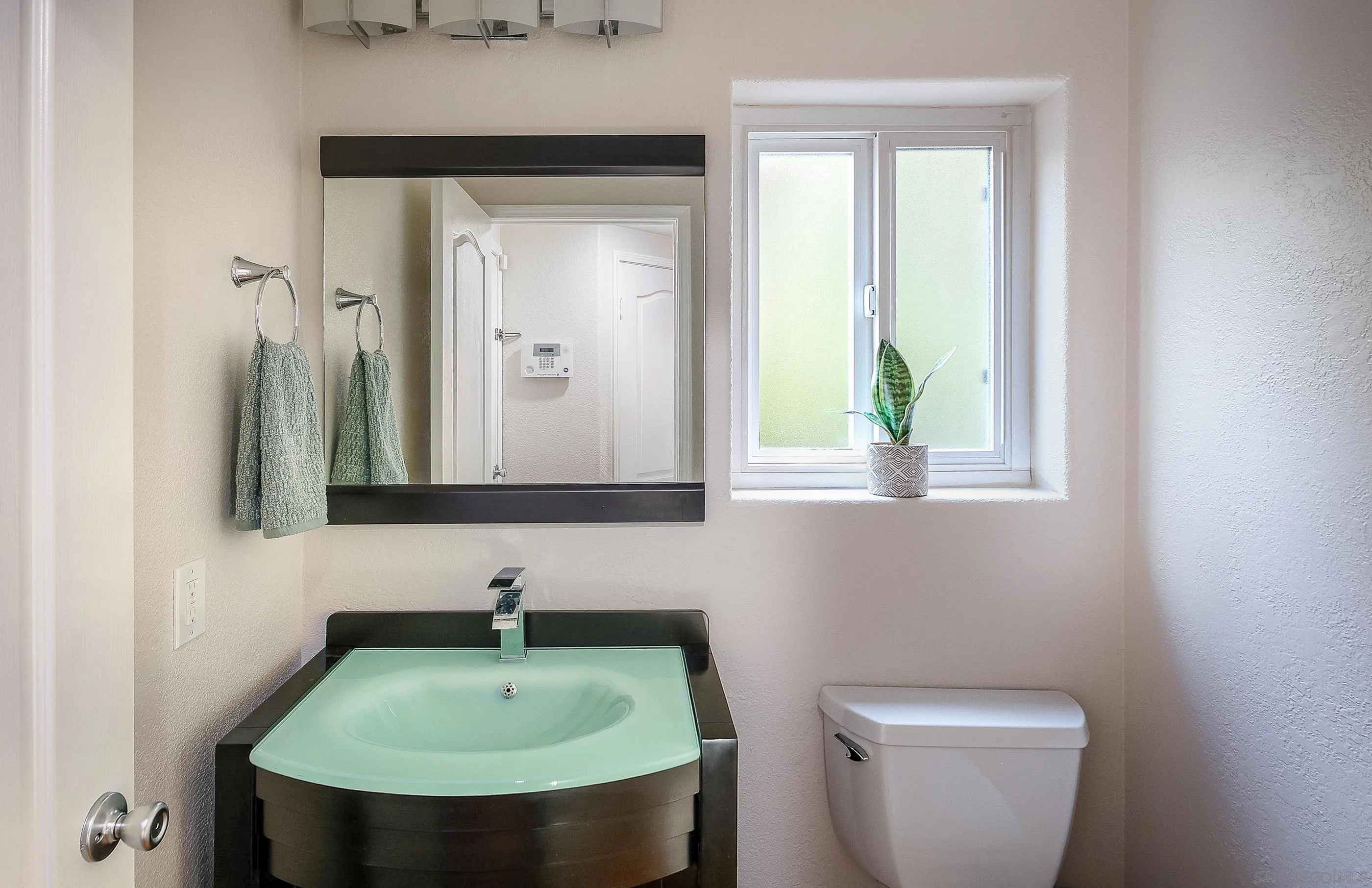 2347 Terraza Ribera Carlsbad, CA 92009 - Photo 19 of 42 a bathroom with a toilet sink and mirror