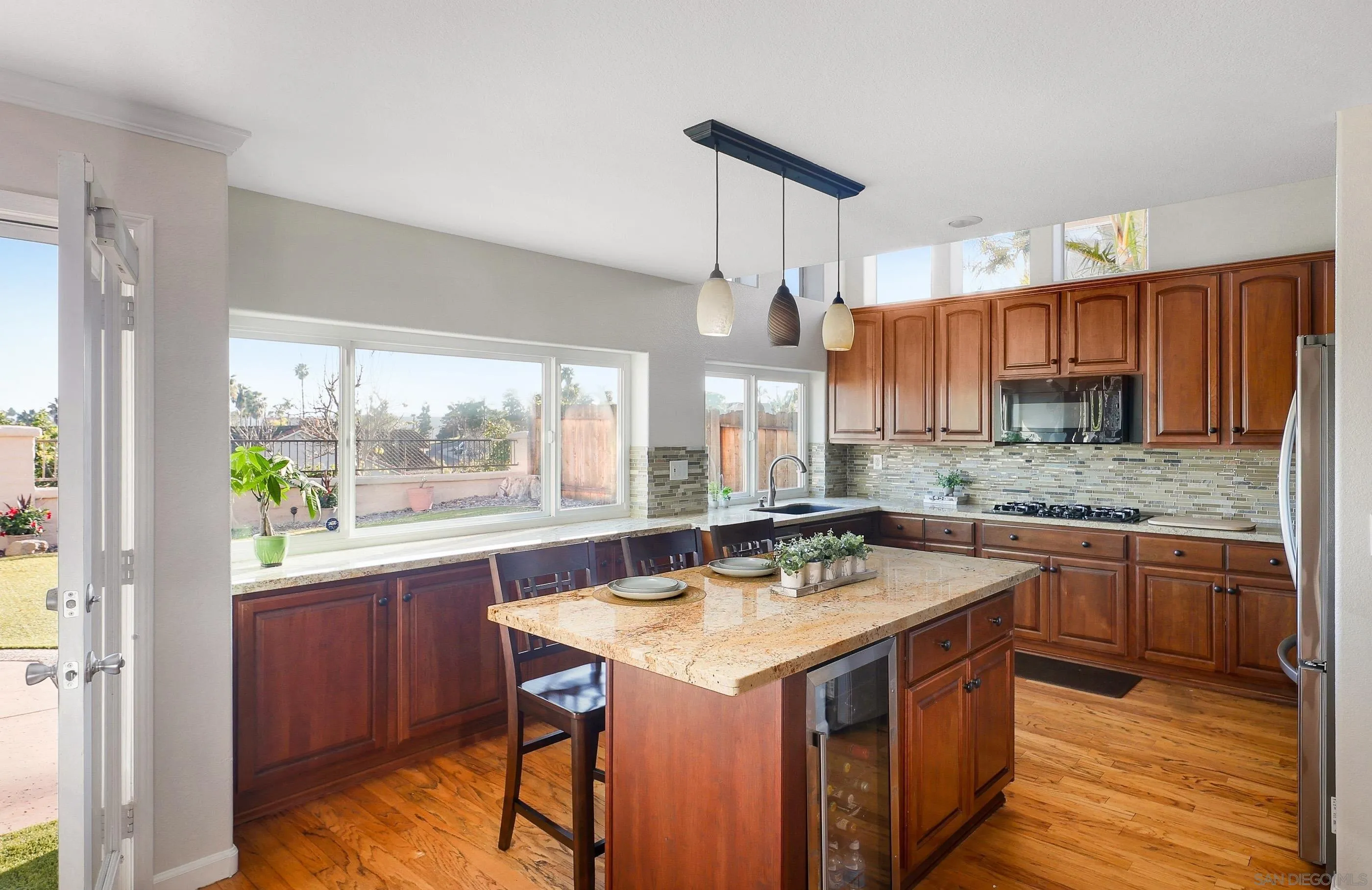 2347 Terraza Ribera Carlsbad, CA 92009 - Photo 9 of 42 a kitchen with a sink stove and wooden cabinets