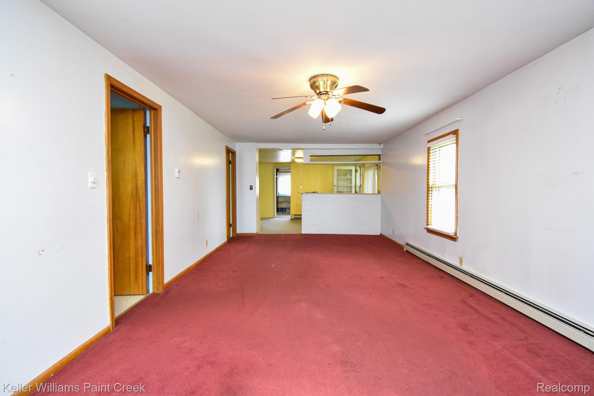 6533 River Road Marine City, MI 48039 - Photo 5 of 17 Empty room featuring carpet, ceiling fan, and a baseboard radiator