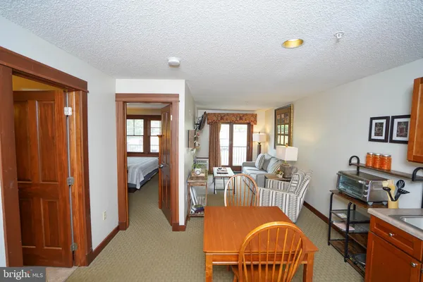 a view of a livingroom with furniture a dinning room and windows