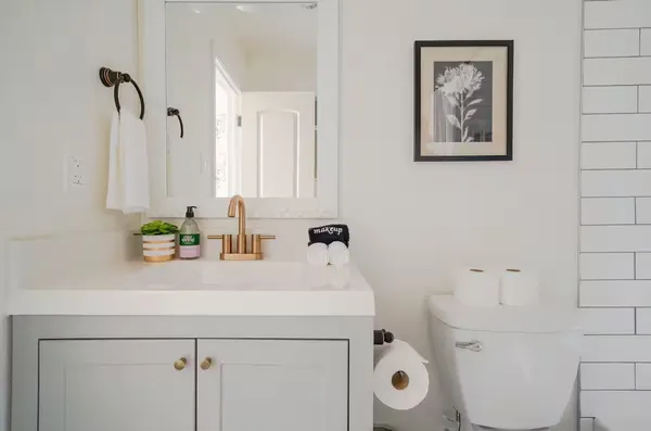 a bathroom with a sink a toilet and a mirror