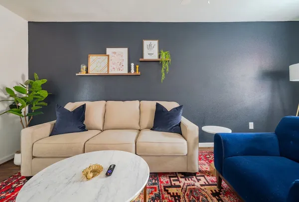 a living room with furniture and painting on the wall