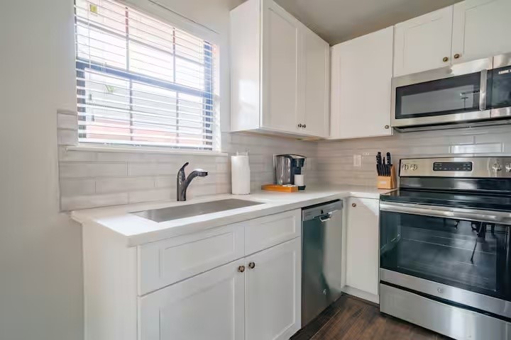 1912 Arbor Street, Unit 3 Houston, TX 77004 - Photo 7 of 24 a kitchen with stainless steel appliances granite countertop white cabinets a sink and a stove