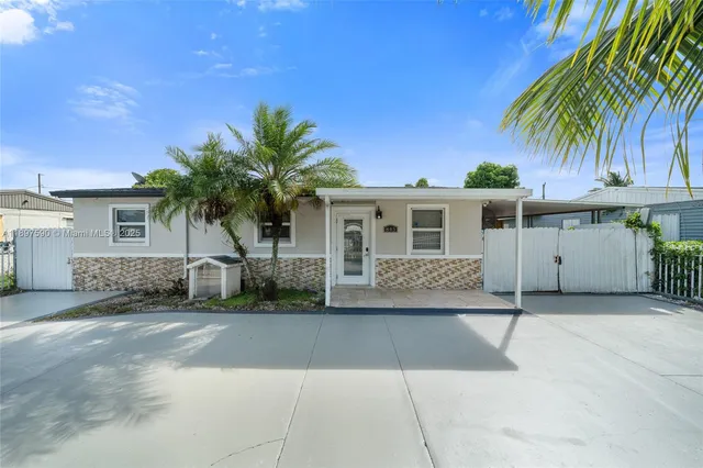 a front view of house with yard and trees around