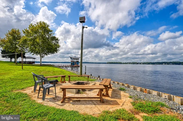 a kitchen with a sink dishwasher a stove and white cabinets with wooden floor