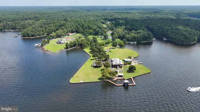 an aerial view of a house with swimming pool a yard and lake view