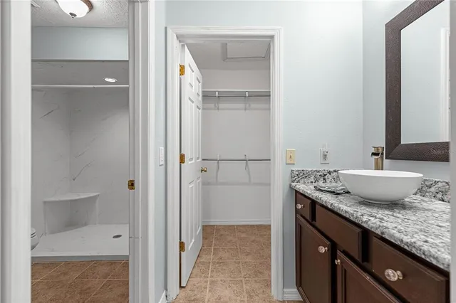 a bathroom with a granite countertop sink and a mirror