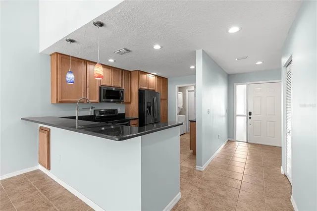 a kitchen with stainless steel appliances granite countertop a sink and a refrigerator