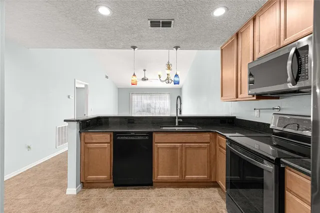 a kitchen with stainless steel appliances a sink stove and microwave