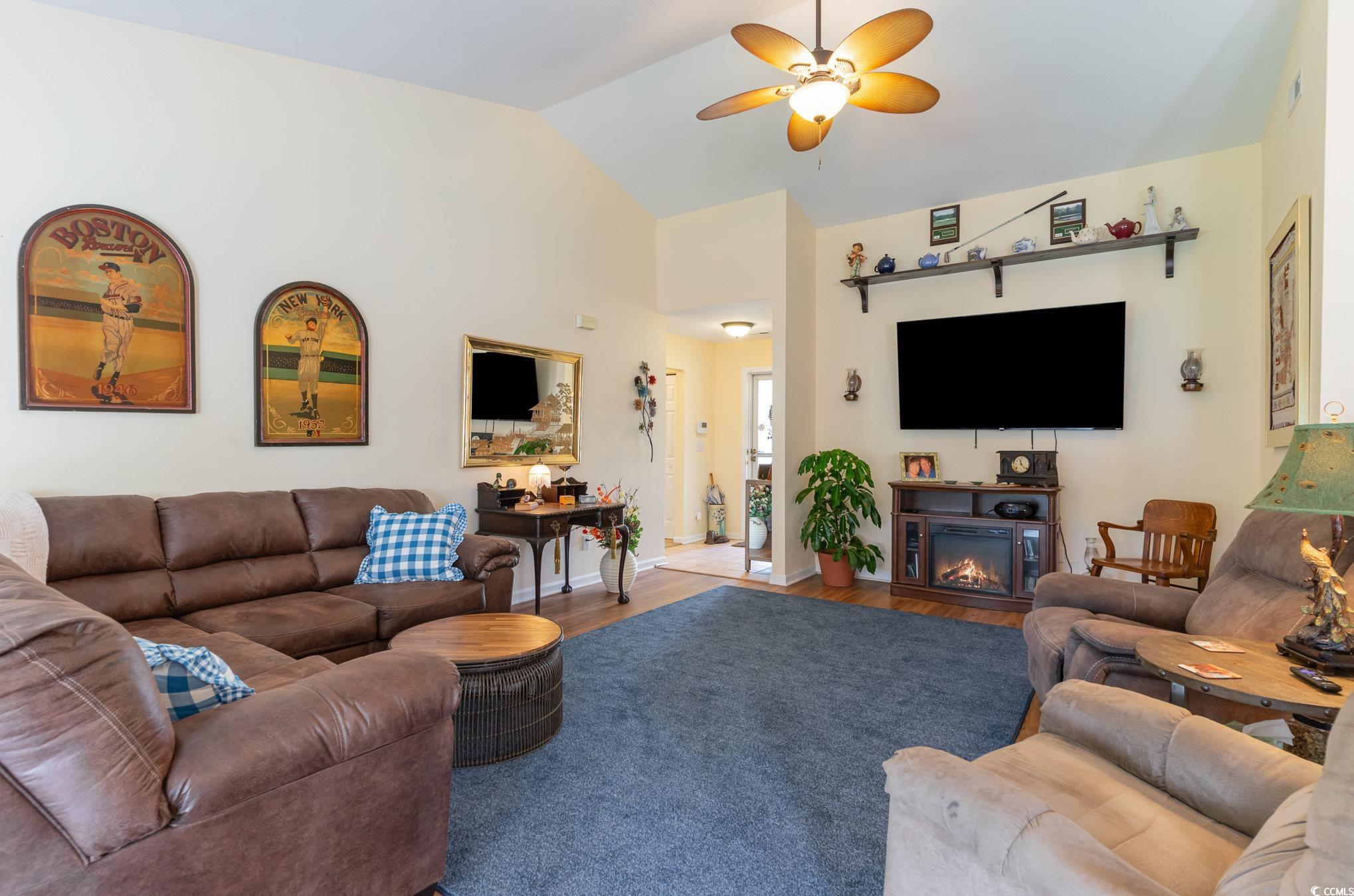 Living room with wood-type flooring, lofted ceilin