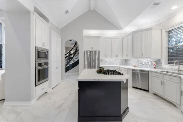 a kitchen with stainless steel appliances granite countertop a stove sink and cabinets
